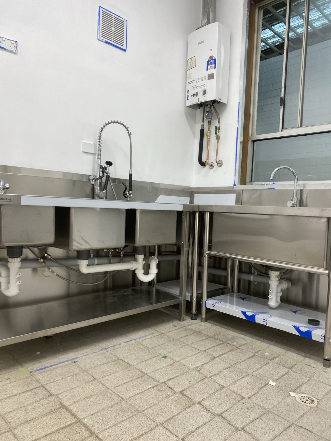Stainless steel commercial kitchen sinks and gas hot water unit installed by MonkFlo