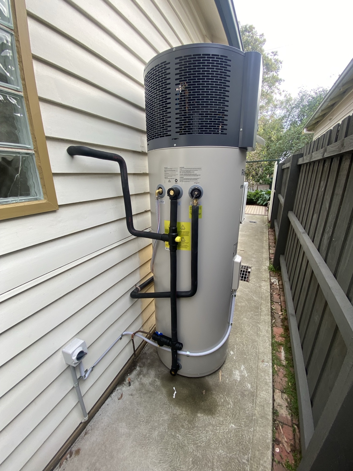 Heat pump hot water system installed beside a weatherboard Melbourne home